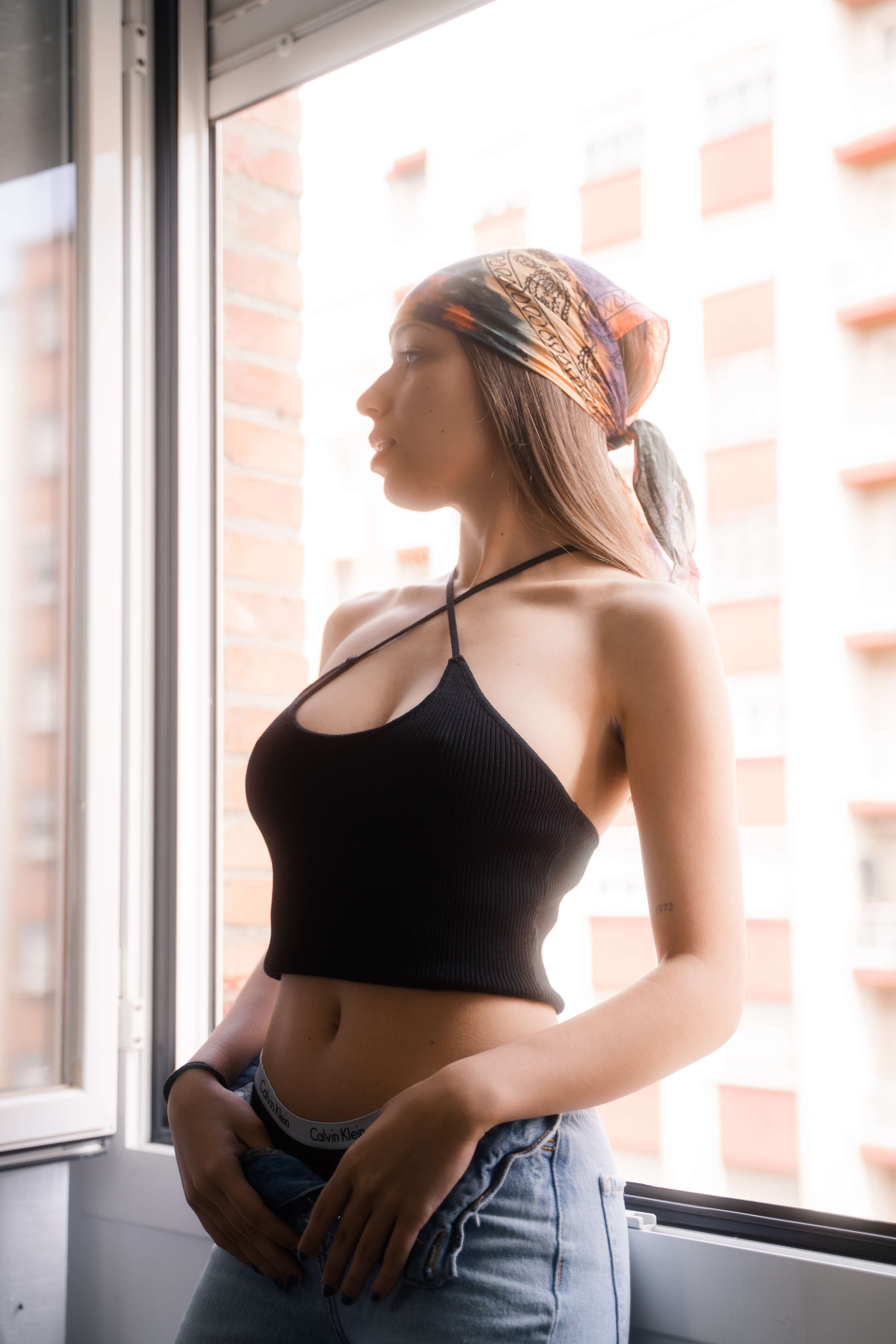 Mujer con bandana en luz dorada, ventana