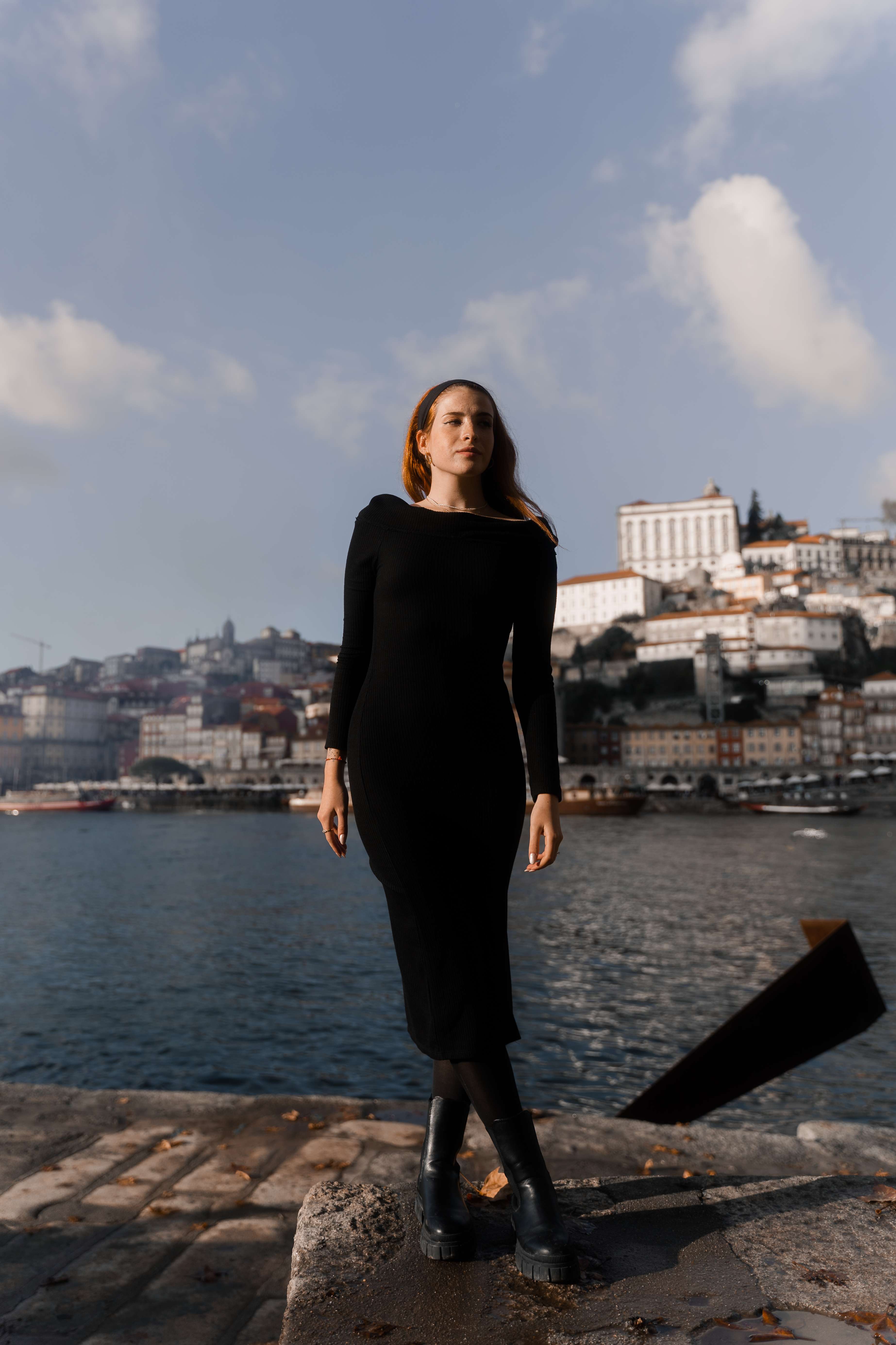 Mujer de negro sobre roca con Ribeira al fondo